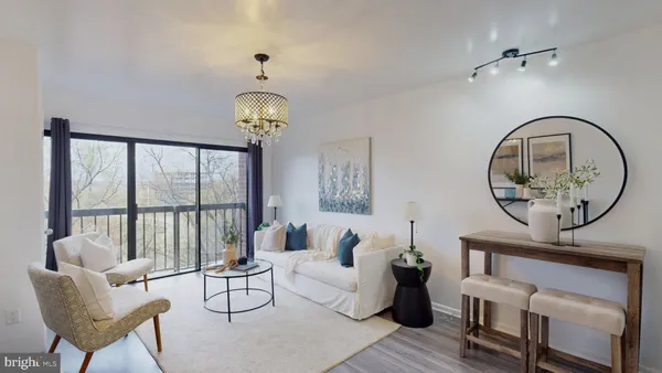 a living room with furniture a chandelier and a large mirror