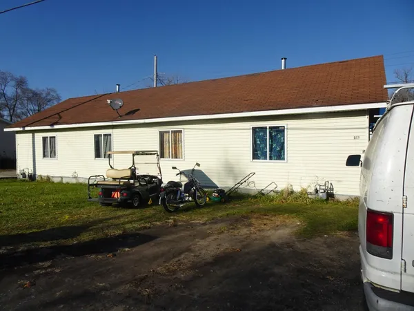 a backyard of a house with table and chairs