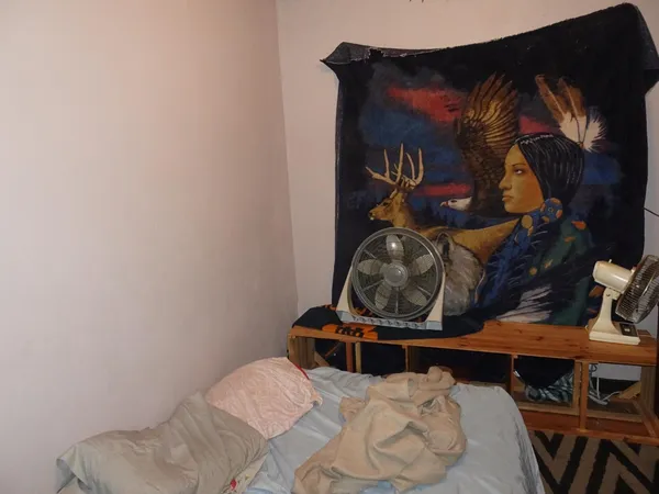 a bedroom with a bed and a painting on the wall