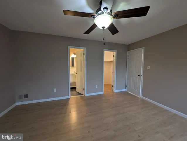 a view of an empty room with a ceiling fan