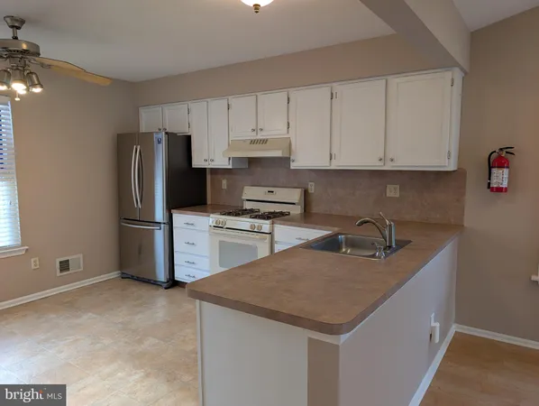 a kitchen with a refrigerator sink and cabinets