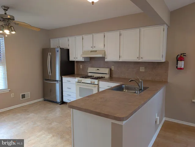 a kitchen with a refrigerator sink and cabinets