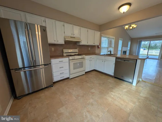 a kitchen with stainless steel appliances a refrigerator sink and cabinets