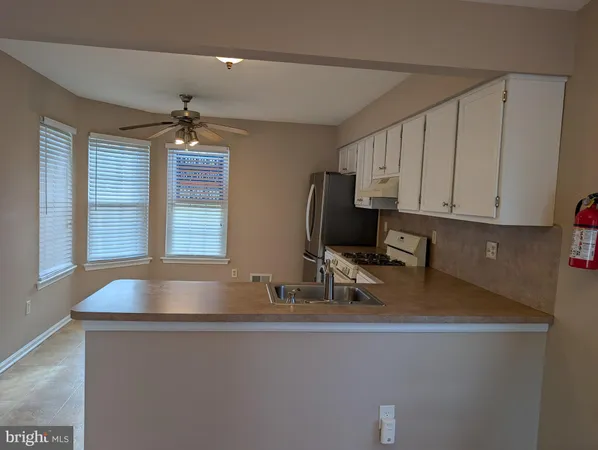a view of kitchen island with stainless steel appliances granite countertop sink and window