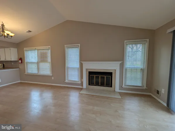 a view of an empty room with a fireplace and a window