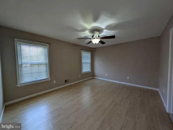 an empty room with wooden floor and window
