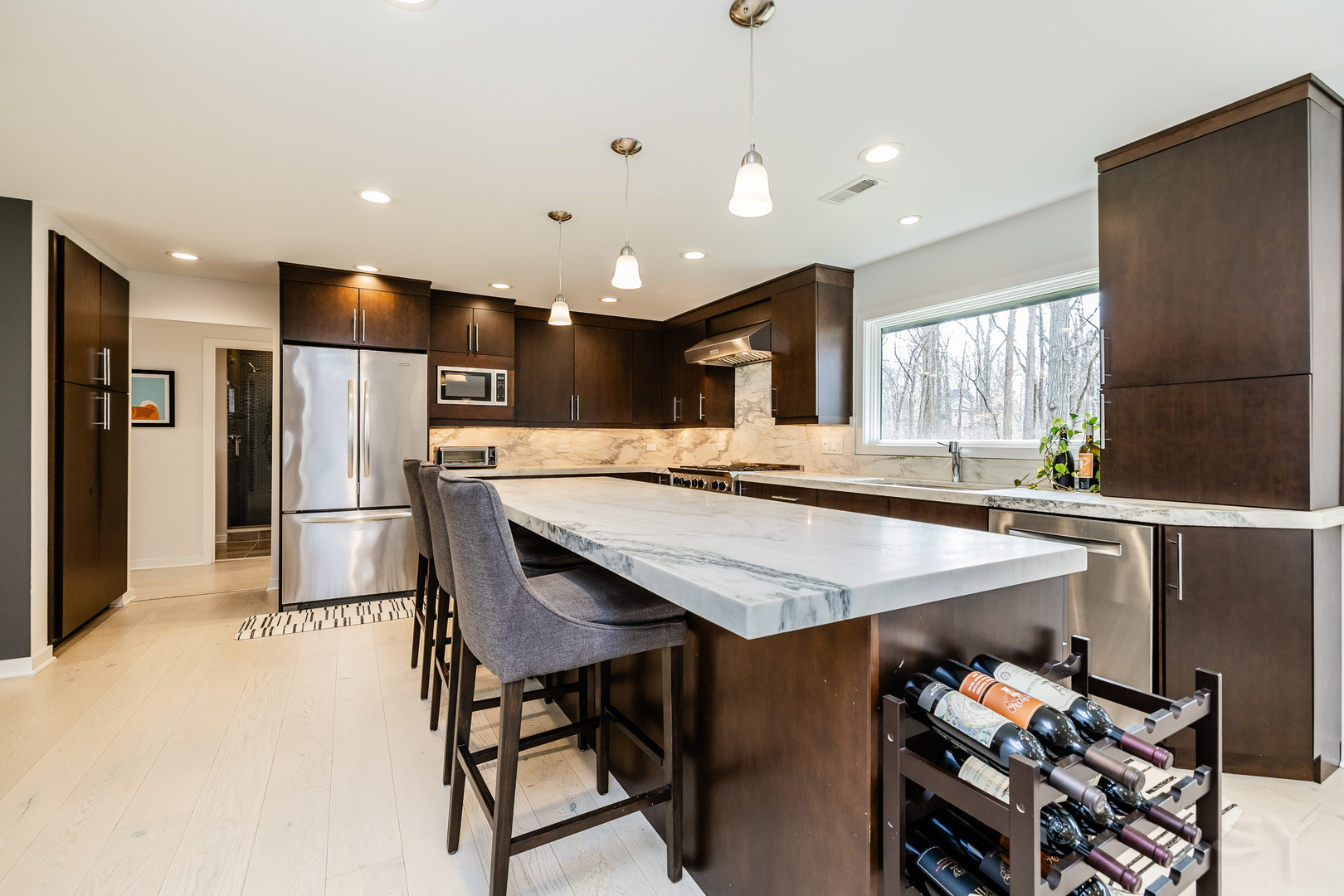 3060 Orange Brace Road Riverwoods, IL 60015 - Photo 9 of 36 a kitchen with stainless steel appliances kitchen island granite countertop a refrigerator a stove and a sink with wooden floor