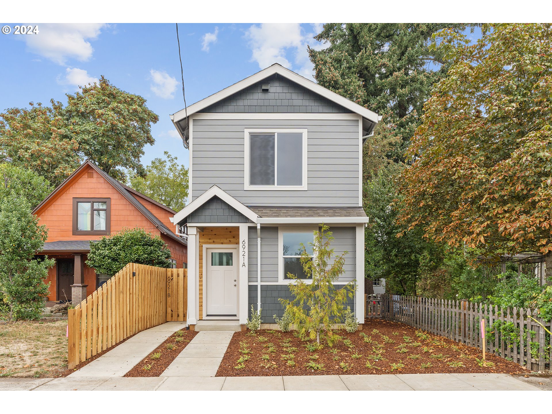 6921 Southeast Pardee Street, Unit A Portland, OR 97206 - Photo 1 of 16 a front view of a house with a yard and garage