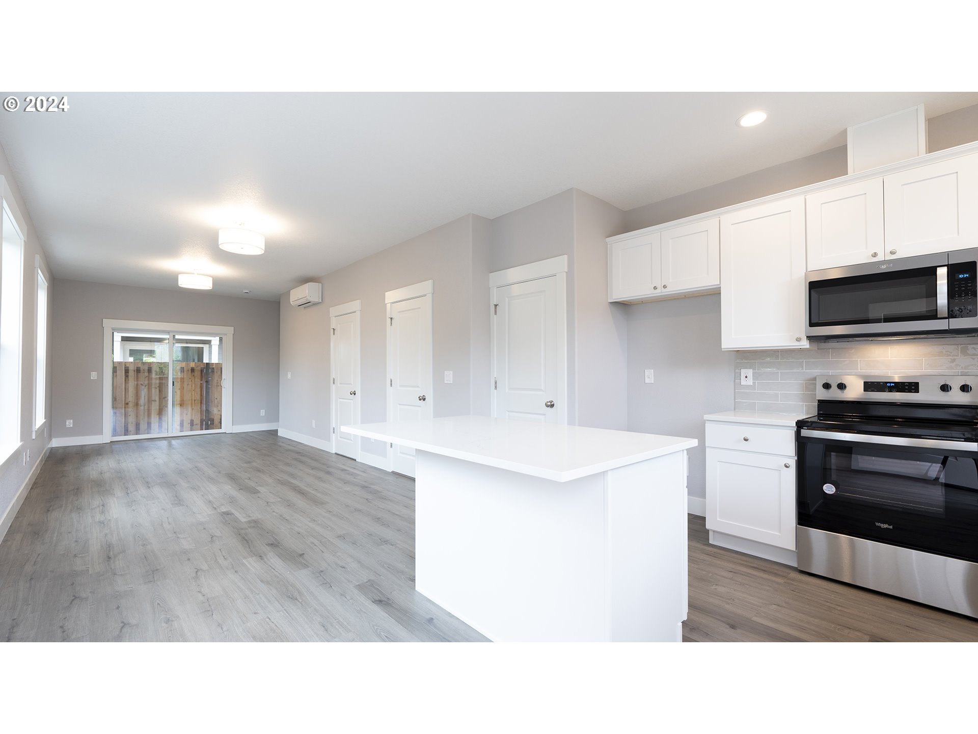6921 Southeast Pardee Street, Unit A Portland, OR 97206 - Photo 3 of 16 a open kitchen with kitchen island a sink stainless steel appliances and cabinets