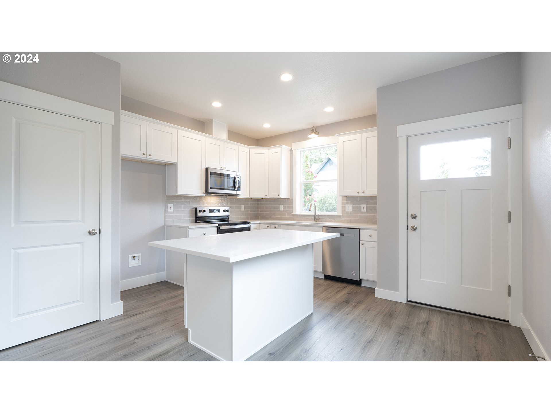 6921 Southeast Pardee Street, Unit A Portland, OR 97206 - Photo 4 of 16 a open kitchen with white cabinets and stainless steel appliances