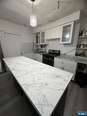 a kitchen with granite countertop sink stove and refrigerator
