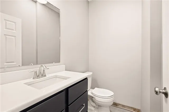 a bathroom with a sink toilet and a mirror