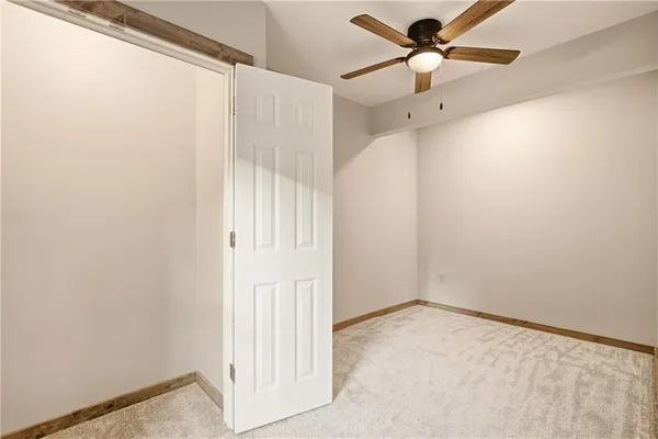 an empty room with a window and a fan