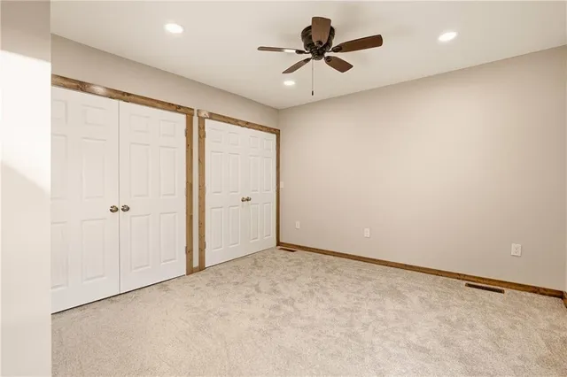 an empty room with a ceiling fan and a window