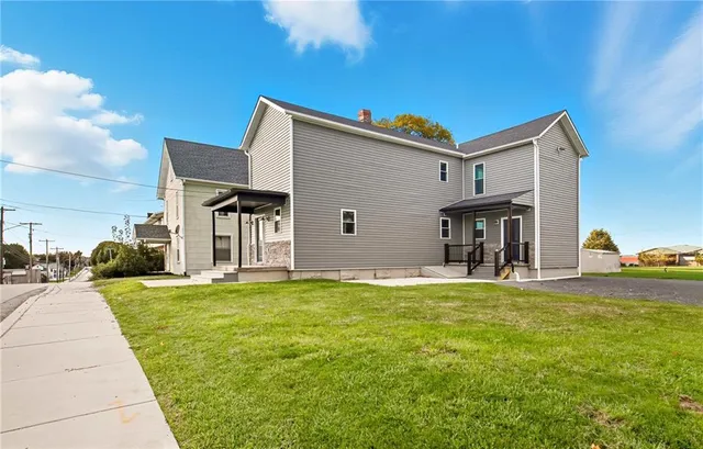 a view of a house with a yard and sitting area