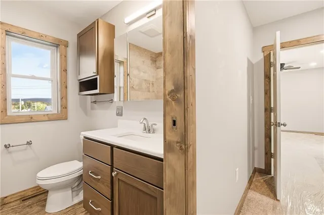 a bathroom with a toilet a sink and a mirror
