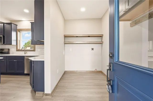 a view of a kitchen with a sink and dishwasher a refrigerator with wooden floor