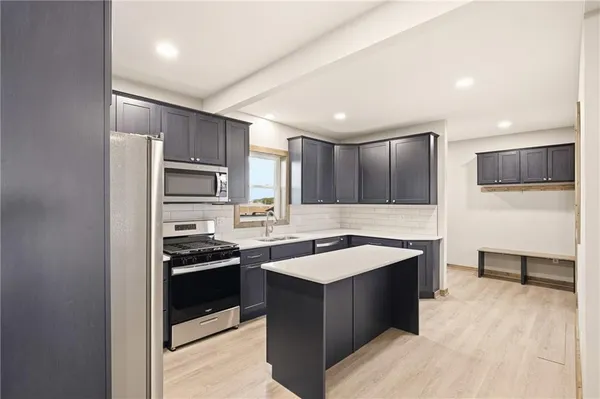 a kitchen with stainless steel appliances granite countertop a sink stove and refrigerator
