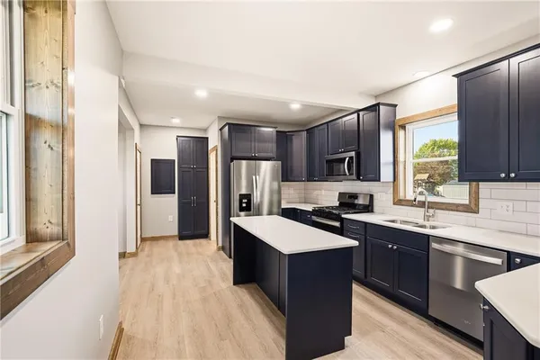 a kitchen with stainless steel appliances granite countertop a sink stove and refrigerator