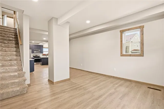 a view of a hallway with wooden floor and a living room