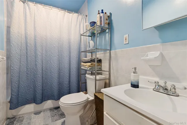 a bathroom with a sink a toilet and shower curtain