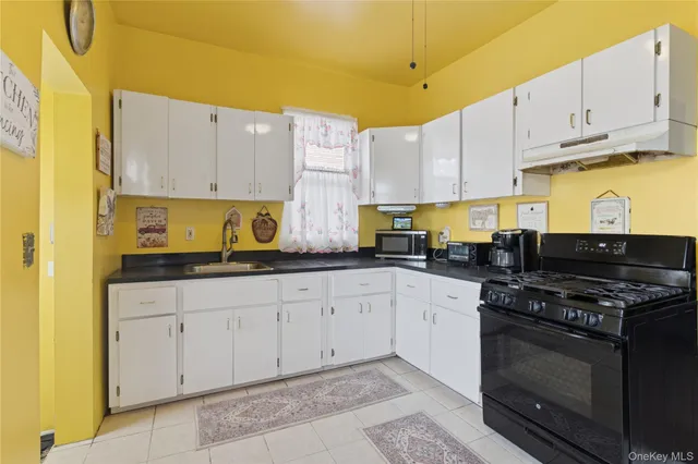 a kitchen with stainless steel appliances granite countertop a stove a sink and a white cabinets