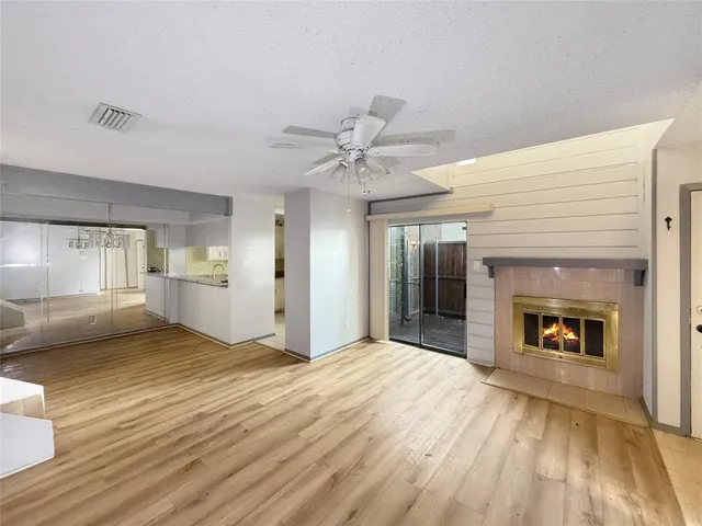 an empty room with a fireplace and wooden floor