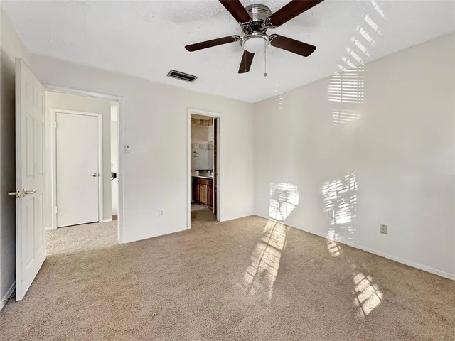 en empty room with windows and ceiling fan