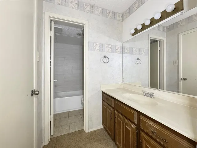 a bathroom with a granite countertop sink a mirror and a shower