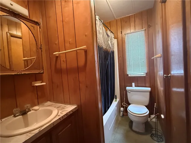an empty room with a chandelier fan and windows