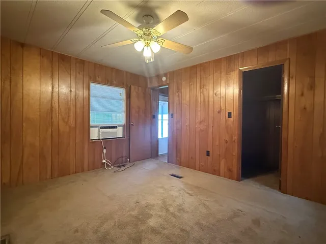 a view of an empty room with a kitchen and a window