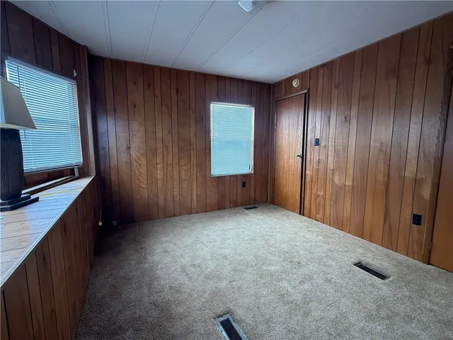 a view of an empty room with window and cabinet