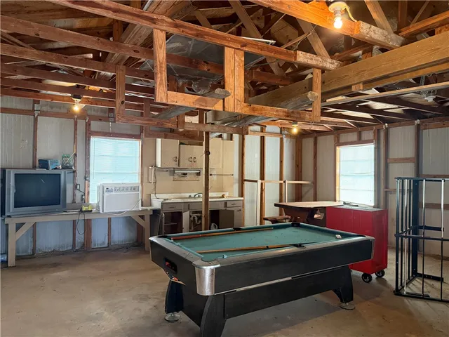 a room with pool table windows and flat screen tv