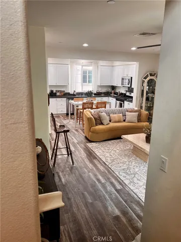 a living room with furniture and a view of kitchen