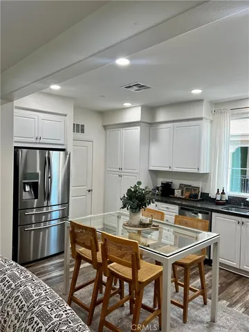 a kitchen with a table chairs refrigerator and microwave