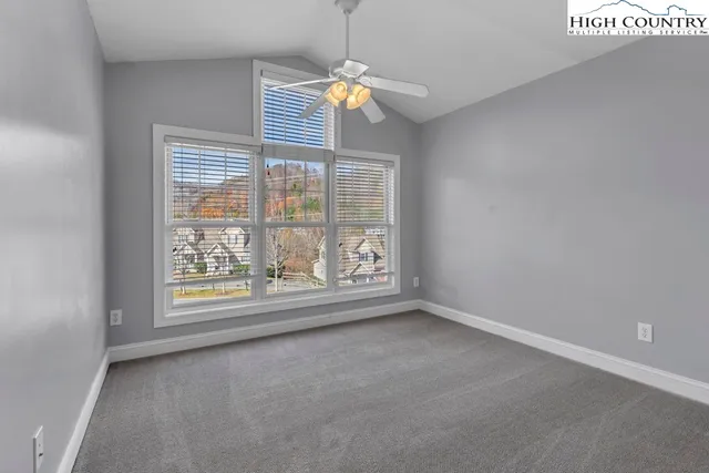 an empty room with windows and chandelier