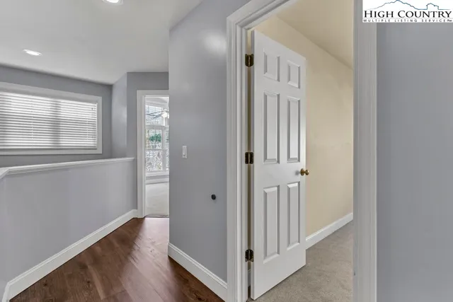 a view of a hallway with wooden floor and windows
