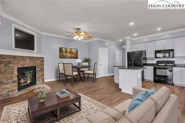 a living room with furniture a flat screen tv and kitchen view