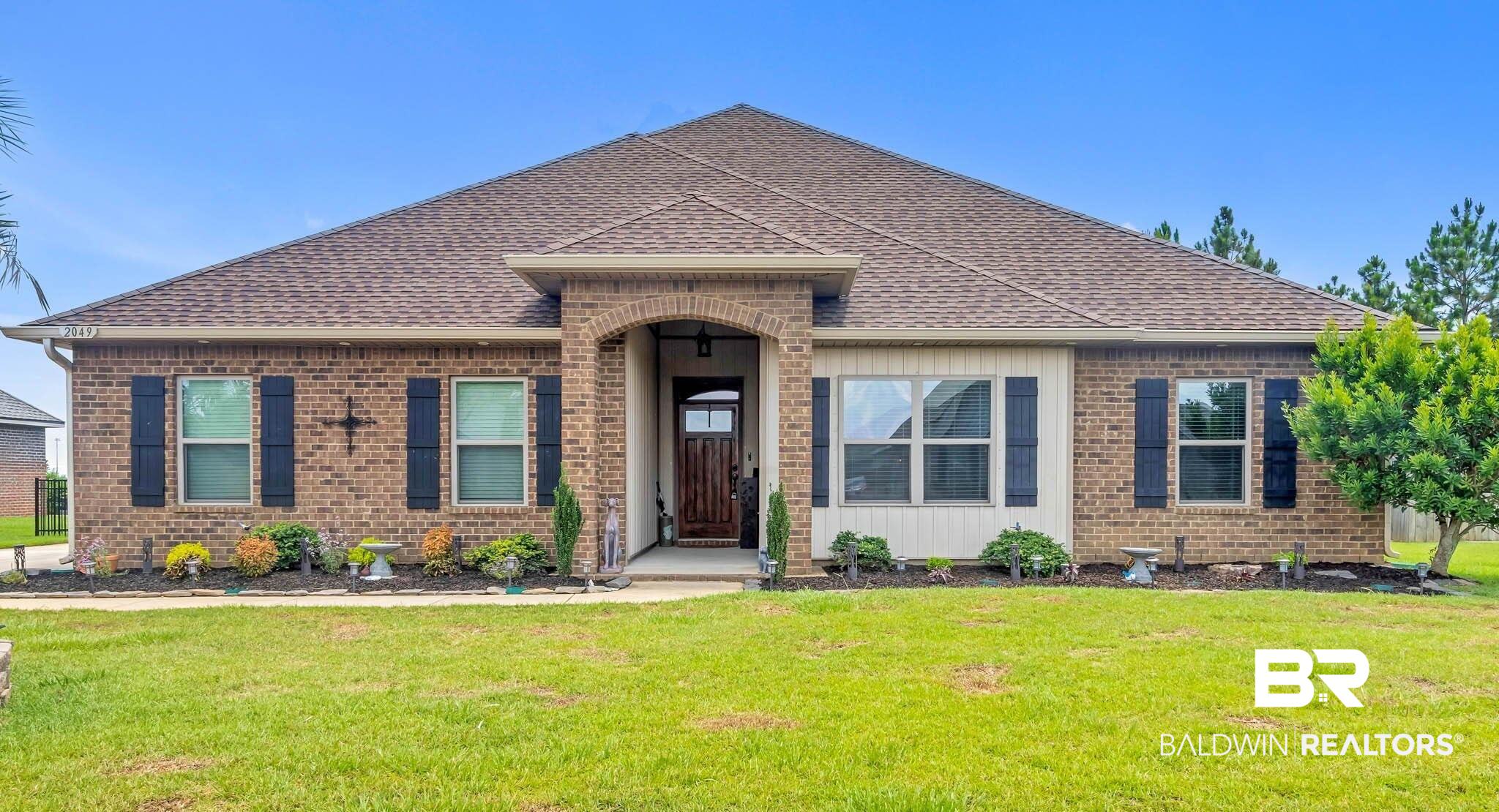 2049 Bourbon Street Foley, AL 36535 - Photo 1 of 56 View of front of house featuring a shingled roof, brick siding, and a front lawn