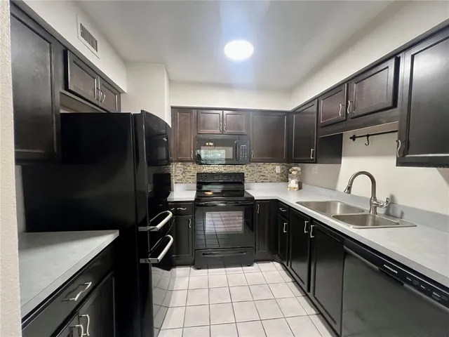 a kitchen with a sink stainless steel appliances and cabinets