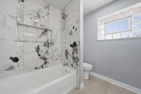 a bathroom with a bathtub and a toilet