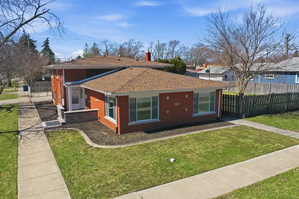a view of a house with a big yard and large tree