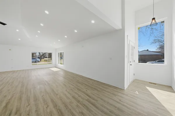 a view of a hallway with wooden floor and cabinet
