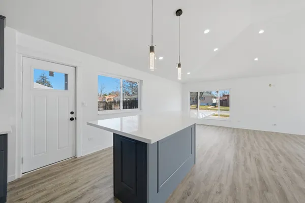 a view of a kitchen with wooden floor and electronic appliances