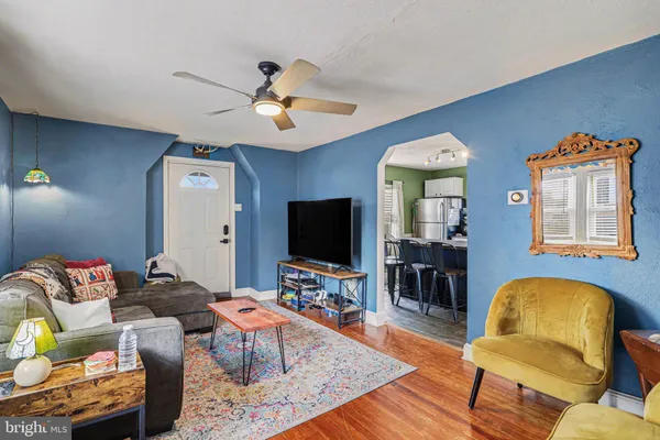 a living room with furniture flat screen tv and wooden floor