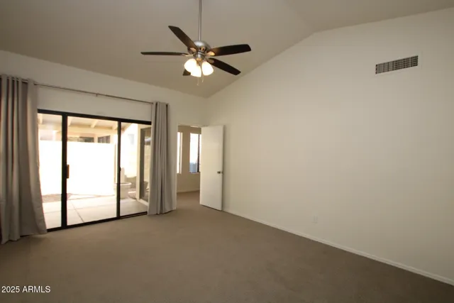 an empty room with chandelier fan