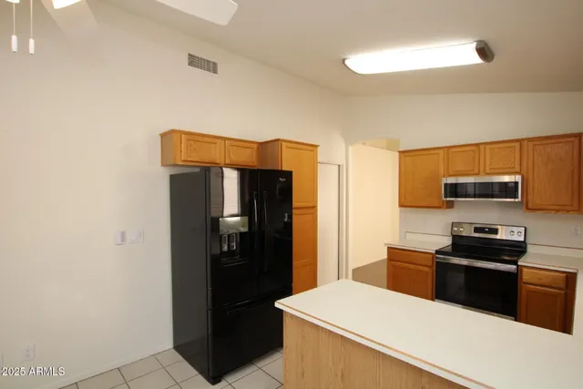 a kitchen with stainless steel appliances a refrigerator and a stove top oven