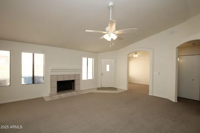 a view of an empty room with a fireplace and a window