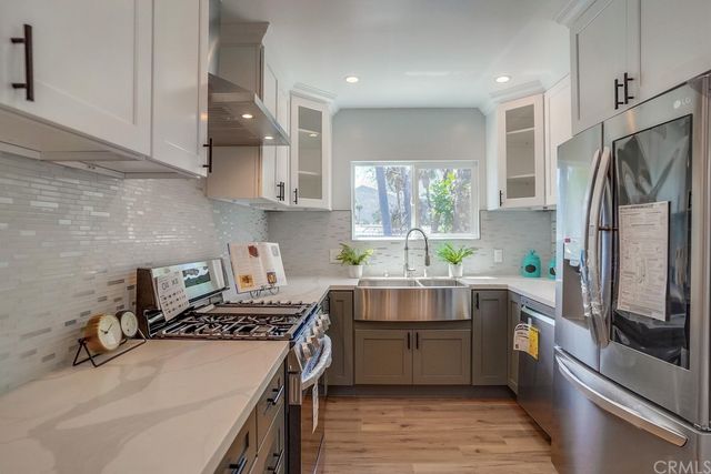 a kitchen with stainless steel appliances a sink window and refrigerator