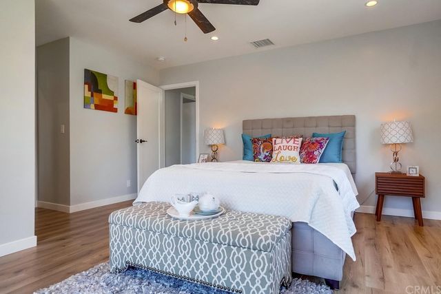 a bedroom with a bed chandelier and a window